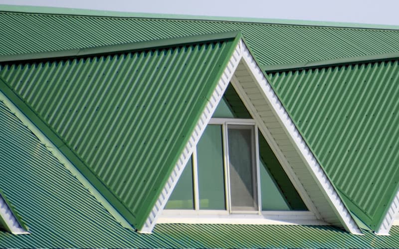 Green corrugated metal roof with a dormer window