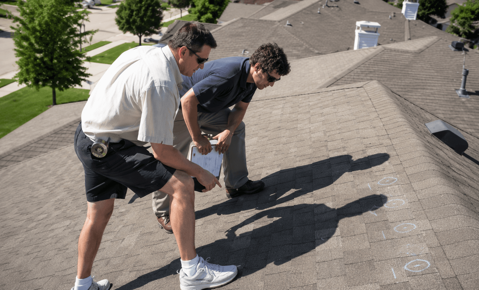 Roof inspectors marking a shingle roof during an inspection