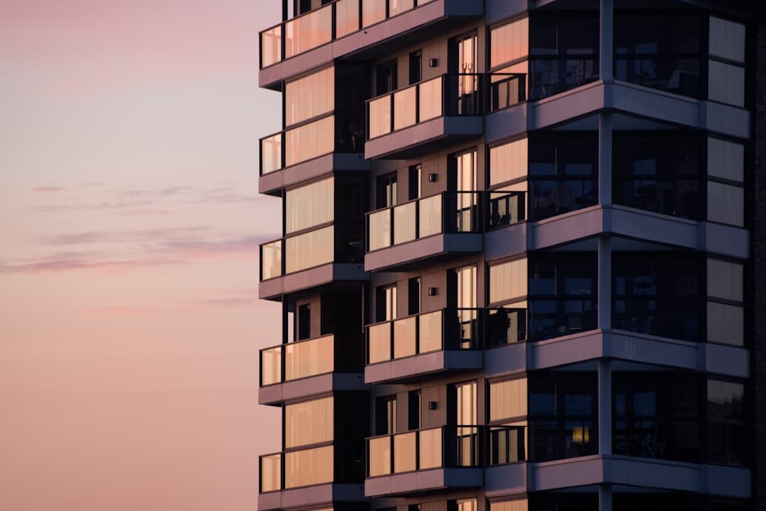 Modern multi-unit apartment building exterior with balconies at sunset