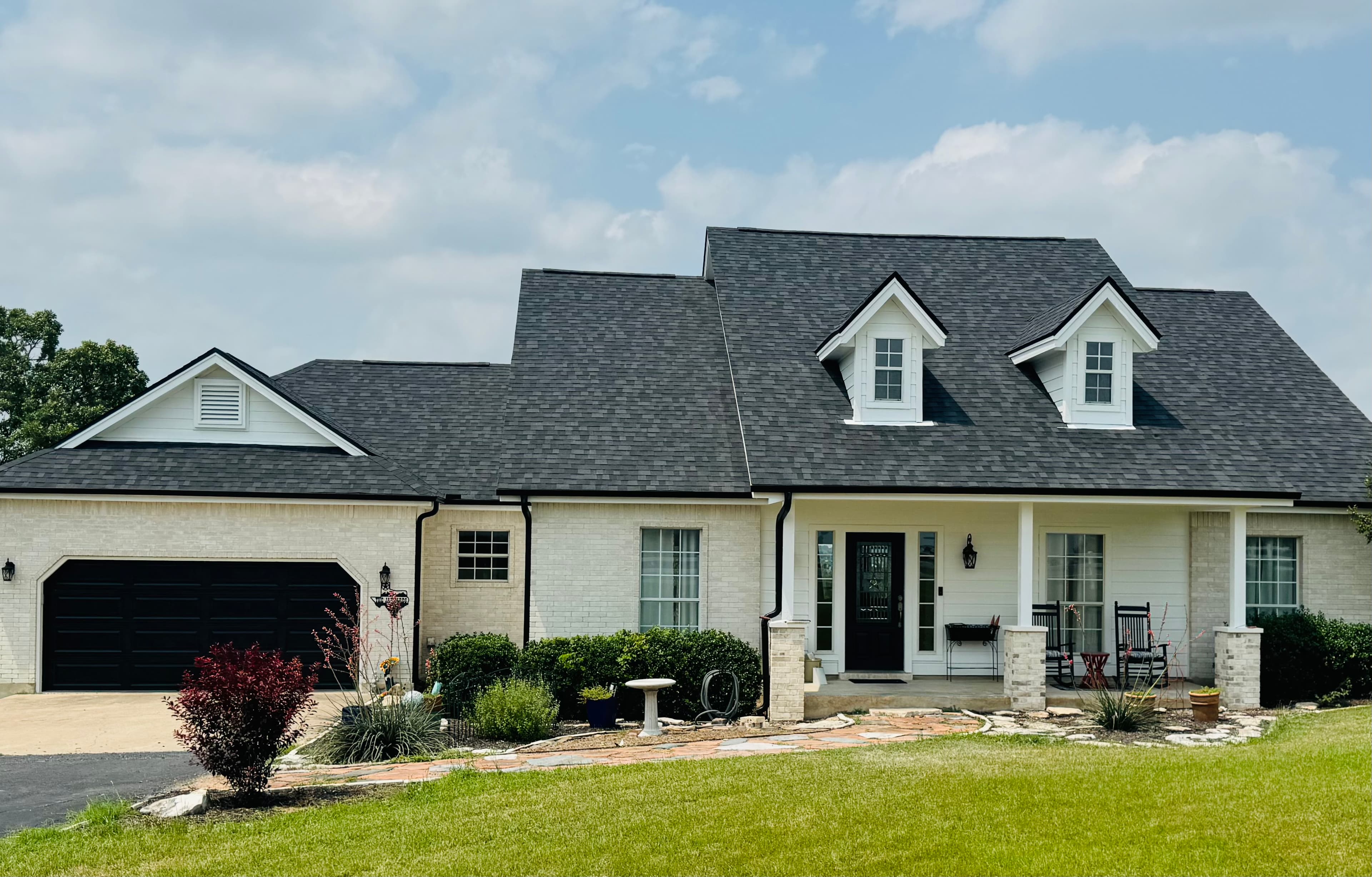White brick ranch home with a newly installed dark grey architectural shingle roof